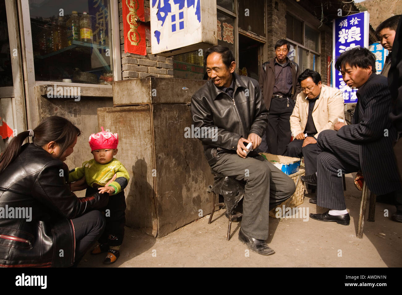 Kartenspieler auf der Straße stoppen, ein kleines Kind zu bewundern. Wutai Shan, der Volksrepublik China Stockfoto