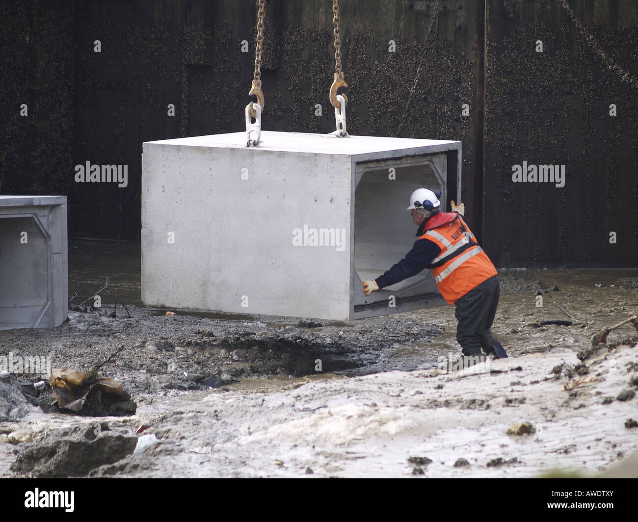 Workman Regie 5 Tonnen Betonblöcken in Bude Kanal, die eingehende Flut so Meer Schleuse entfernt werden können Stockfoto