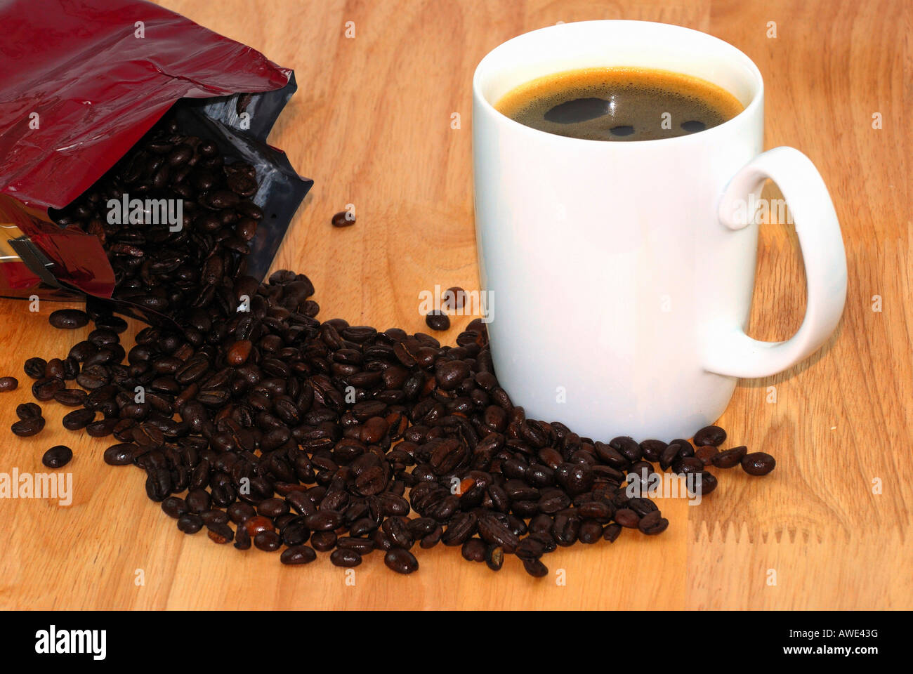 heiße Tasse Kaffee umgeben mit Kaffeebohnen Stockfoto