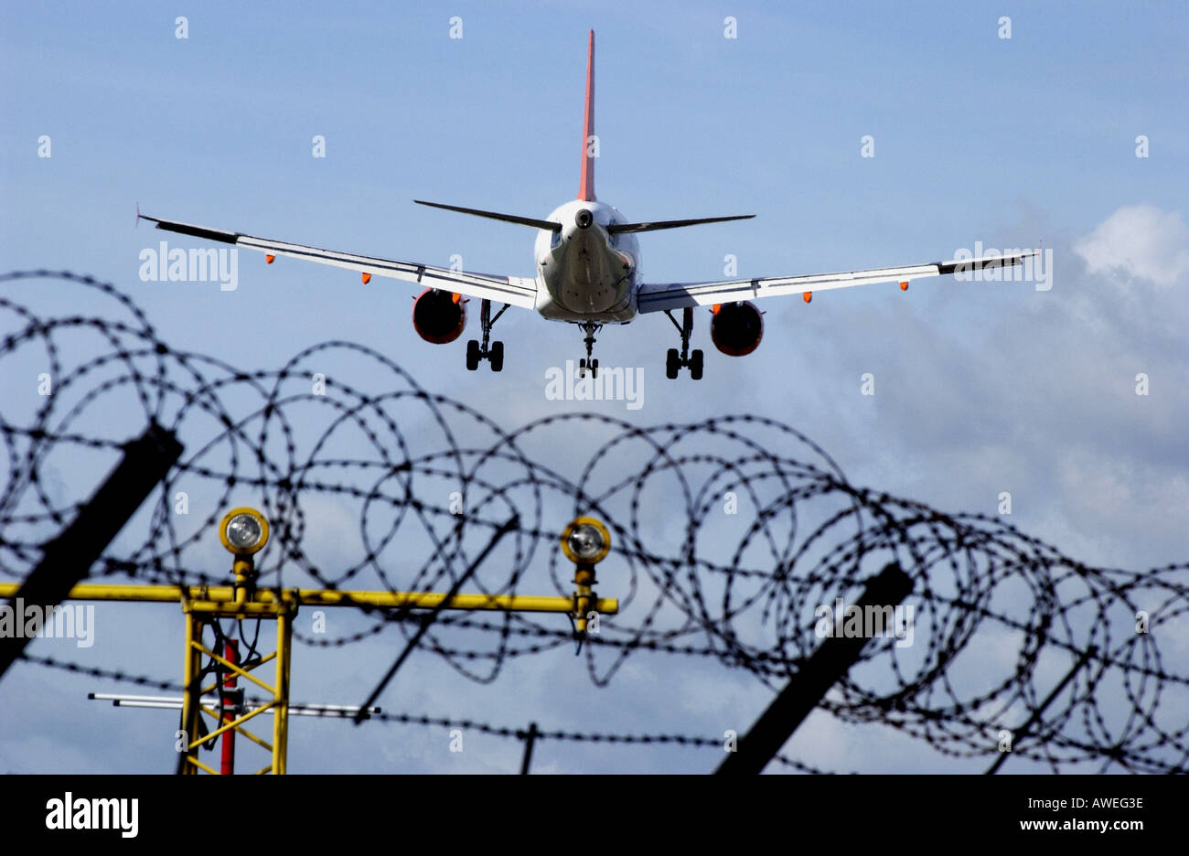 Ein EasyJet-Jet landet am Flughafen Gatwick über den Stacheldraht-Umzäunung Stockfoto