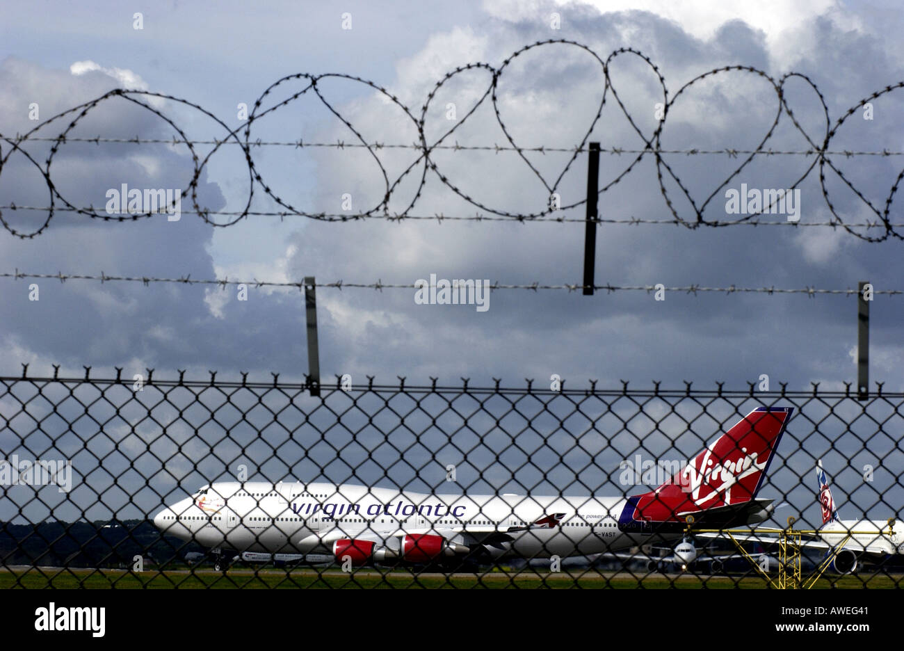 Virgin Atlantic Airways Boeing 747 Jumbo Jet gesehen durch Stacheldraht am Flughafen Gatwick Stockfoto