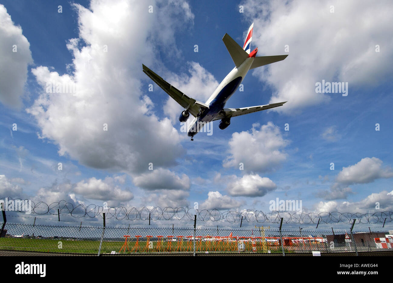 Ein British Airways-Jet landet am Flughafen Gatwick über den Stacheldraht-Umzäunung Stockfoto