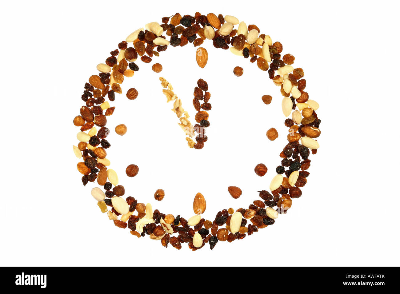Uhr aus Nüssen und Rosinen gemacht; isoliert auf weiss Stockfoto