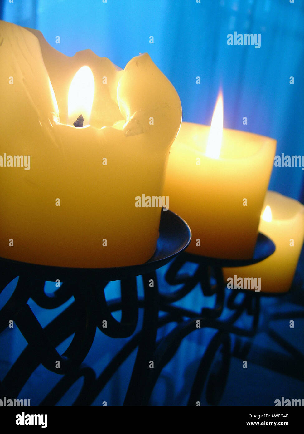 Drei 3 Kerzen in einer Gusseisen Kandelaber auf einem Glastisch kopieren Raum Stockfoto