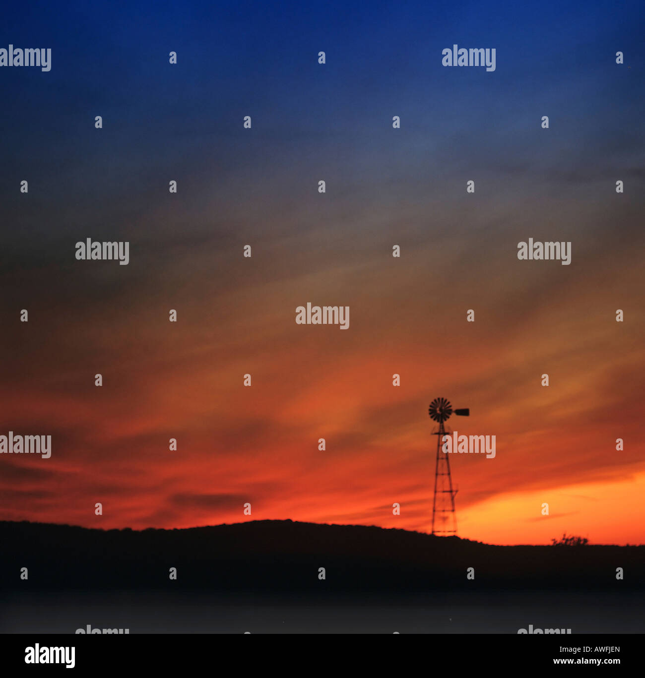 Wind-Pumpe Silhouette gegen bunte Nachthimmel Stockfoto