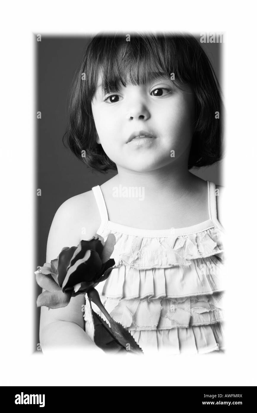 Kind 3 Jahre altes Mädchen mit Rose. Schwarz und weiß. Modell freigegeben Studio gedreht Stockfoto