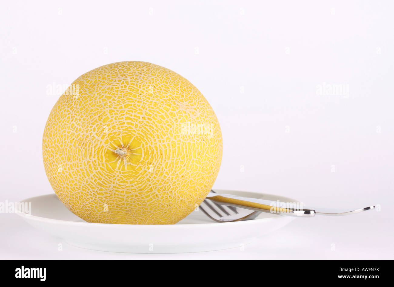 Melone auf einem Teller mit Besteck Stockfoto