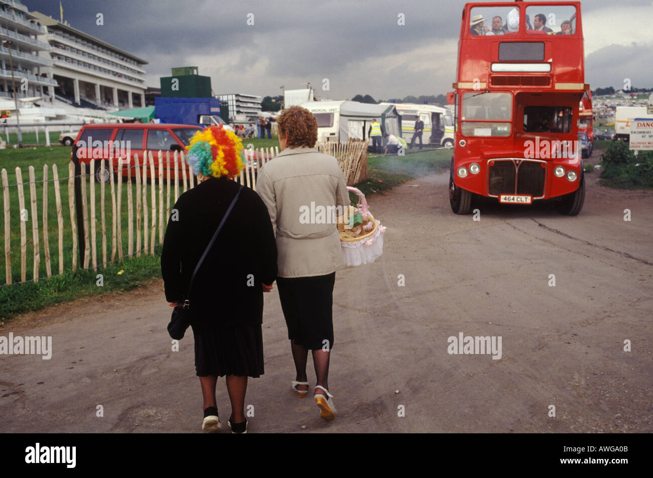 Frau mit farbenfroher Scherzperücke Derby Day Pferderennen Doppeldeckerbus fährt am Ende des Renntages. Epsom Downs Surrey 1985 1980s UK Stockfoto