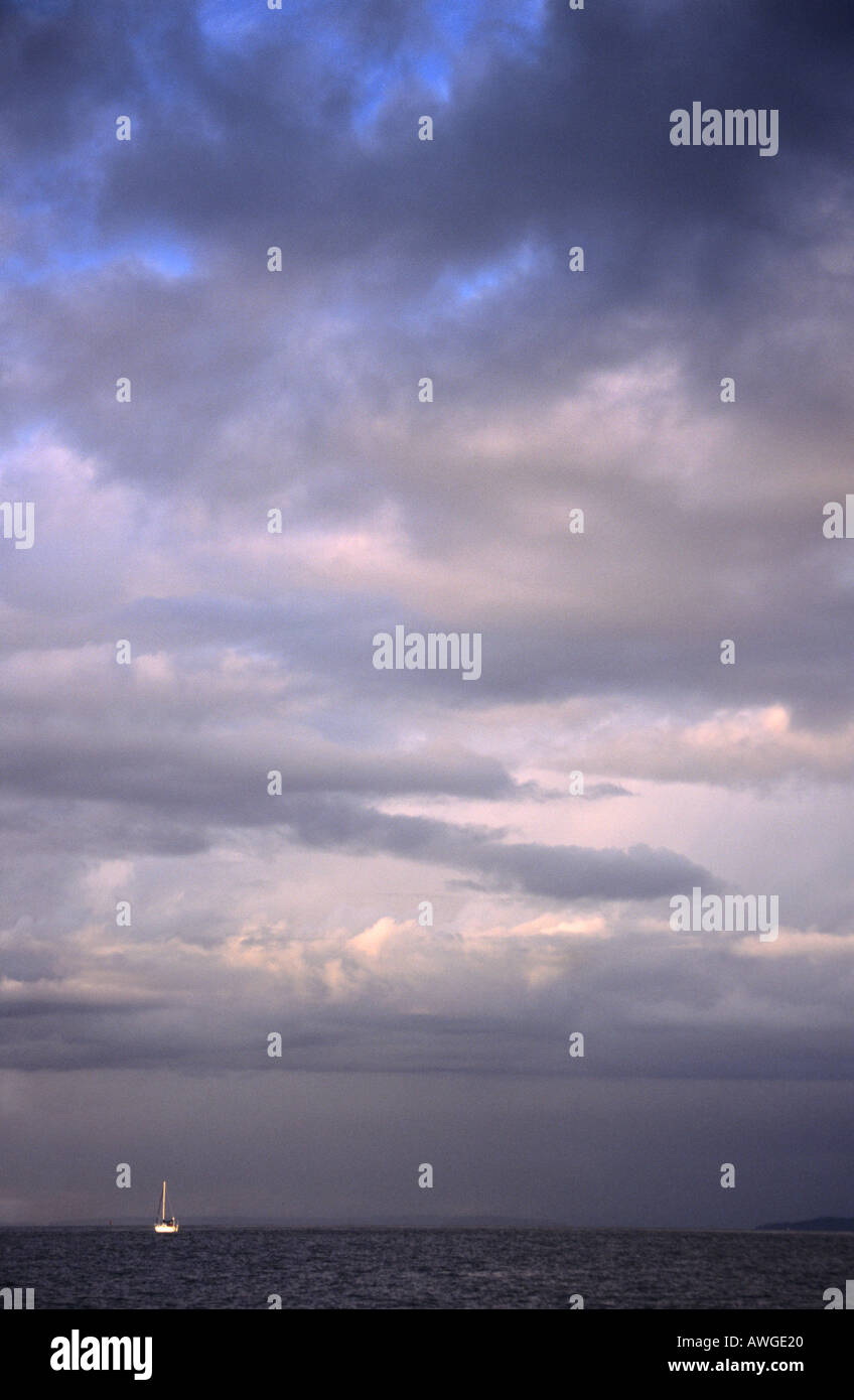 Ein einsames Segelboot unter bewölktem Himmel Stockfoto