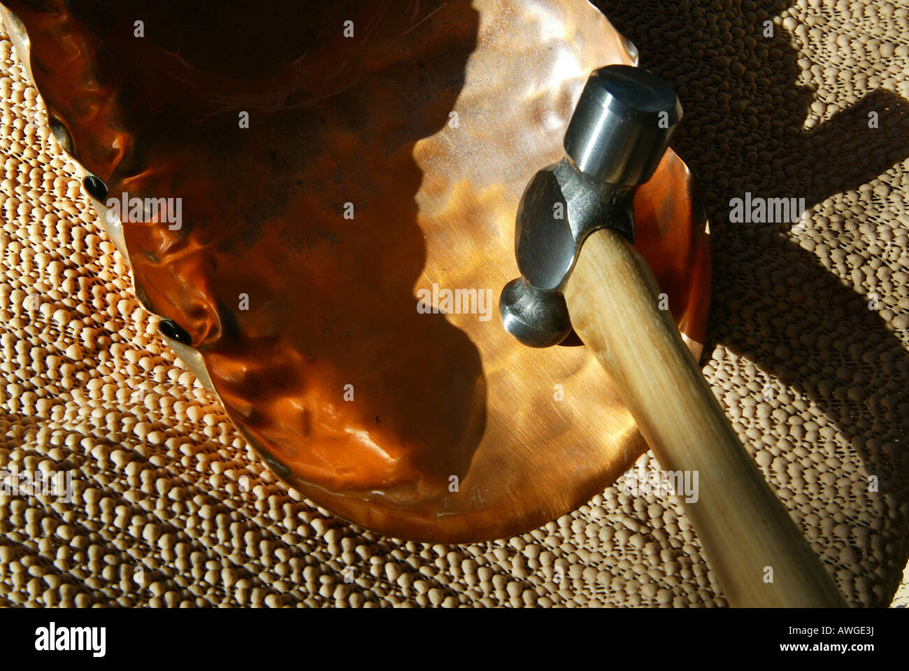 Ball Peen Hammer Formen Kupfer Blatt in Blume Schüssel Stockfoto