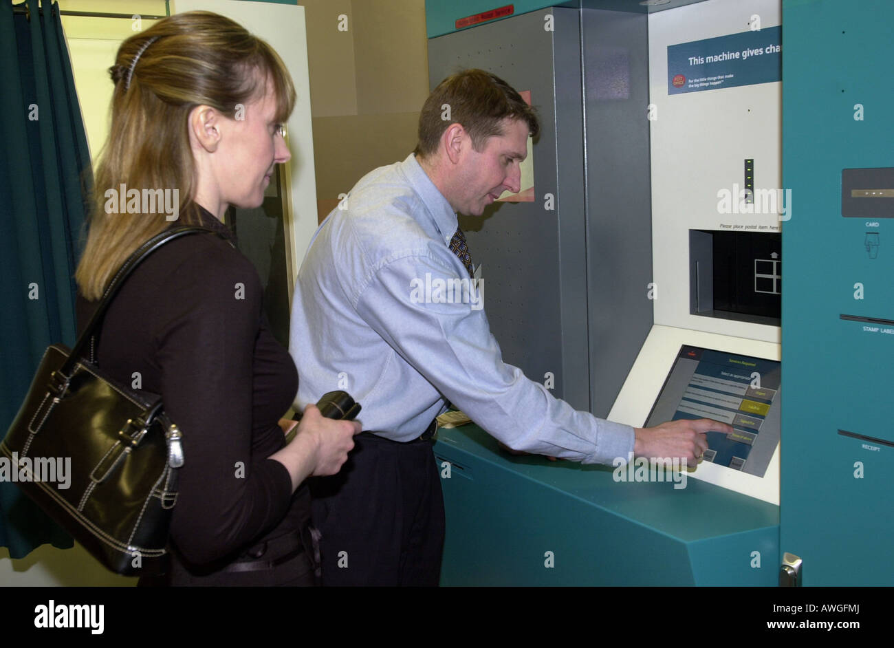 Ein Post-Offizier zeigt ein Mitglied der Öffentlichkeit wie eine automatische Paketautomaten verwenden Stockfoto