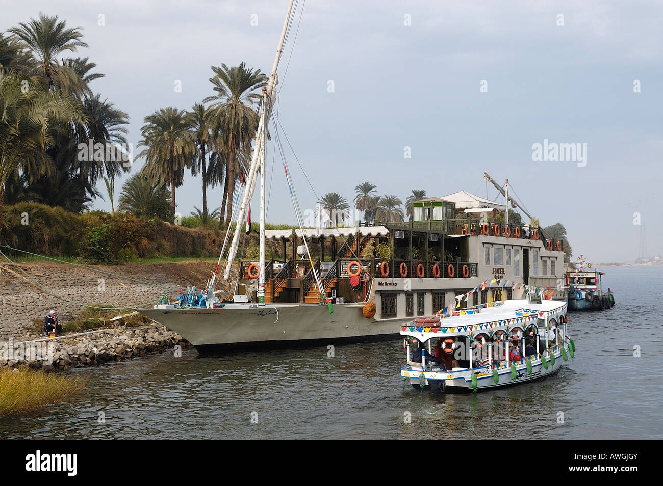 Dahabiyya namens Hadeel vertäut am Westufer bei Theben mit einer Fähre, die Menschen zurück nach Luxor am Ostufer Stockfoto