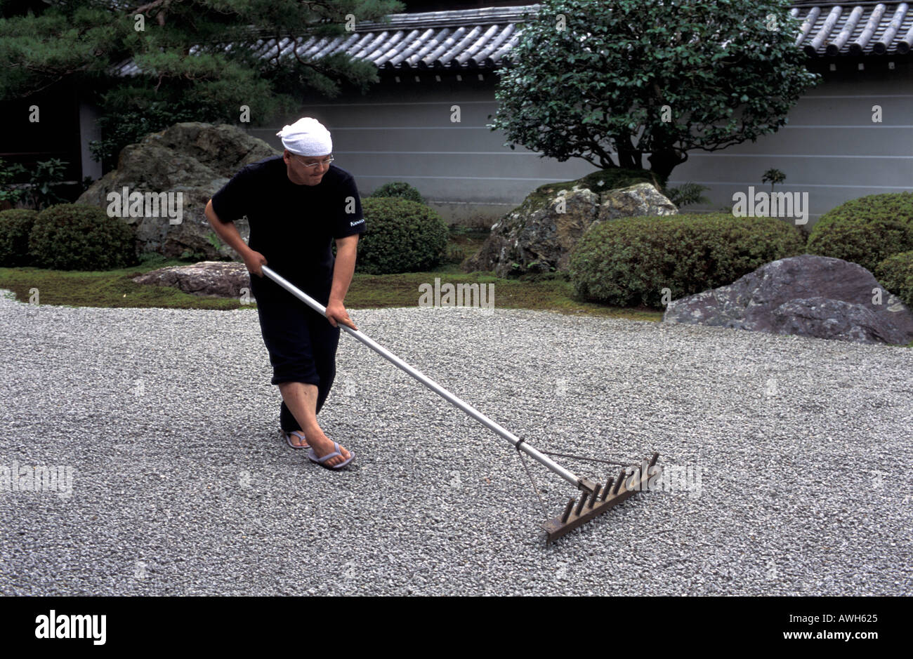 Buddhist monk raking zen garden Fotos und Bildmaterial in hoher