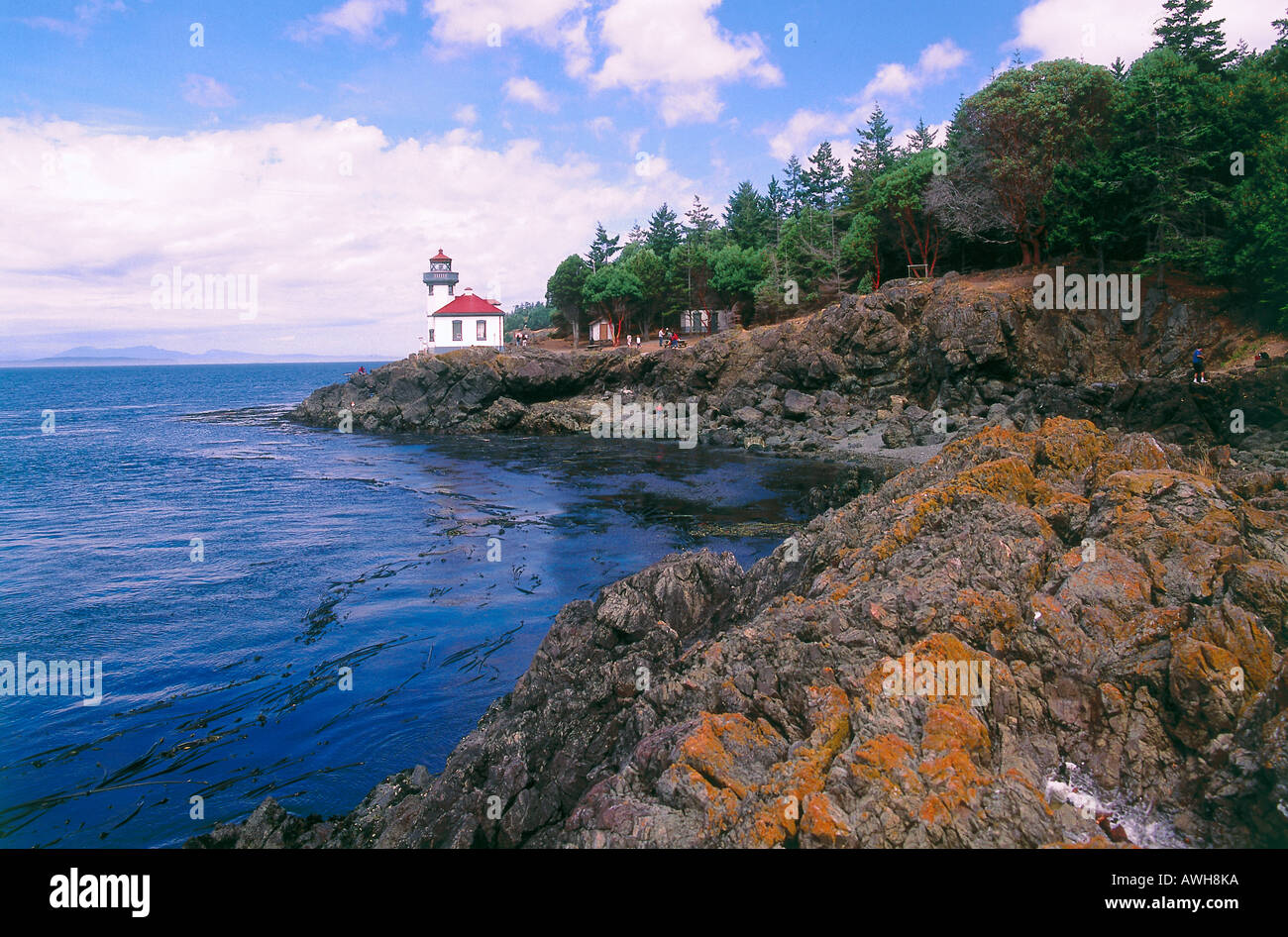 Pacific Northwest, US-Bundesstaat Washington, USA, San Juan Island Lighthouse steht auf Felsvorsprung am Gewässerrand Stockfoto