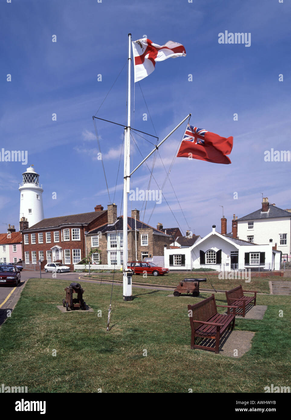 Southwold Seaside Resort Town Flagpole & Flag of St George mit Red Ensign & Working Lighthouse Beyond Suffolk East Anglia England UK Stockfoto