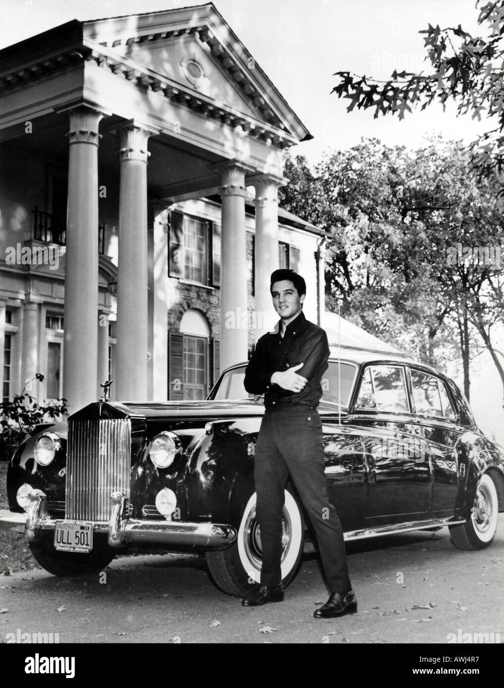 ELVIS PRESLEY posiert mit seinen Rolls-Royce vor dem Eingang zu seinem Gracelands Haus Stockfoto