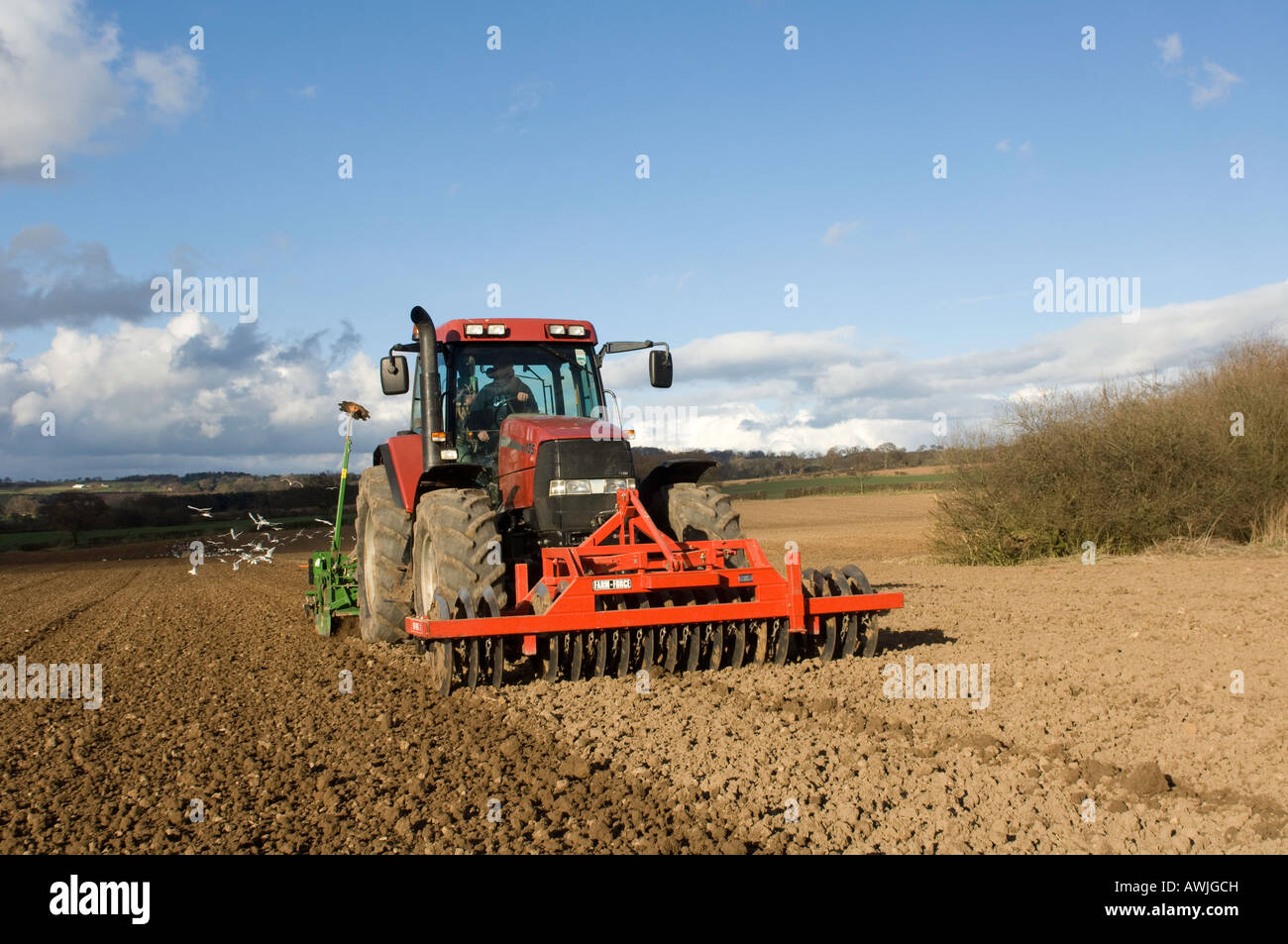 Landwirt Pflanzung Bohnen mit einem pneumatischen Sämaschine montiert auf einem CASE Maxxum Traktor mit front montierte Scheiben ausgestattet Stockfoto