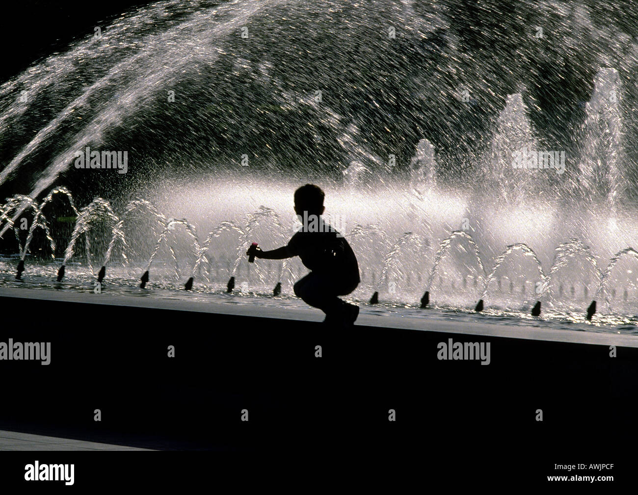 Silhouette der junge kauert am Rand des Brunnens Stockfoto