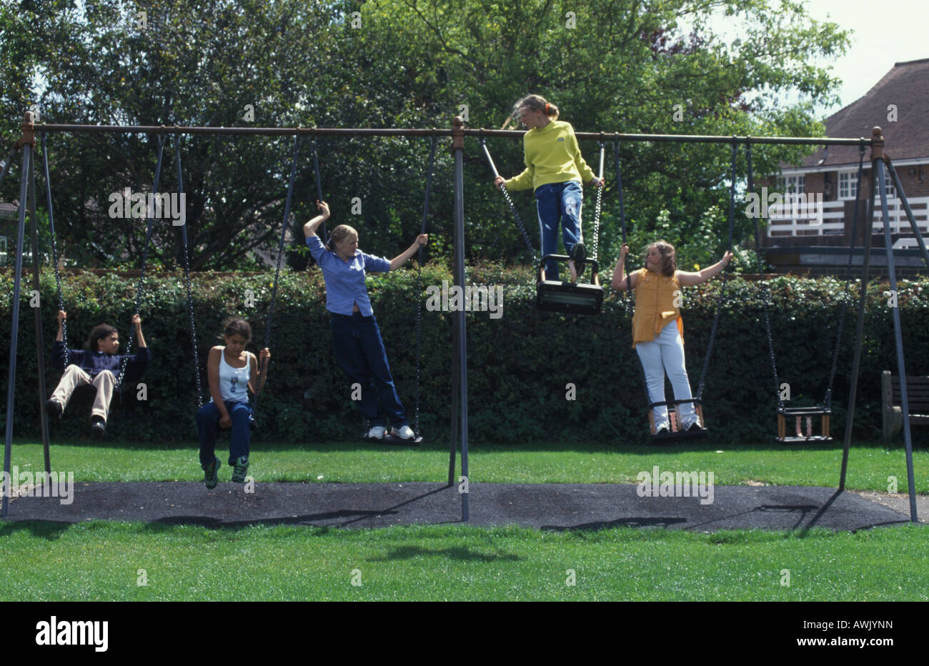 Jugendliche auf Schaukeln im örtlichen park Stockfoto