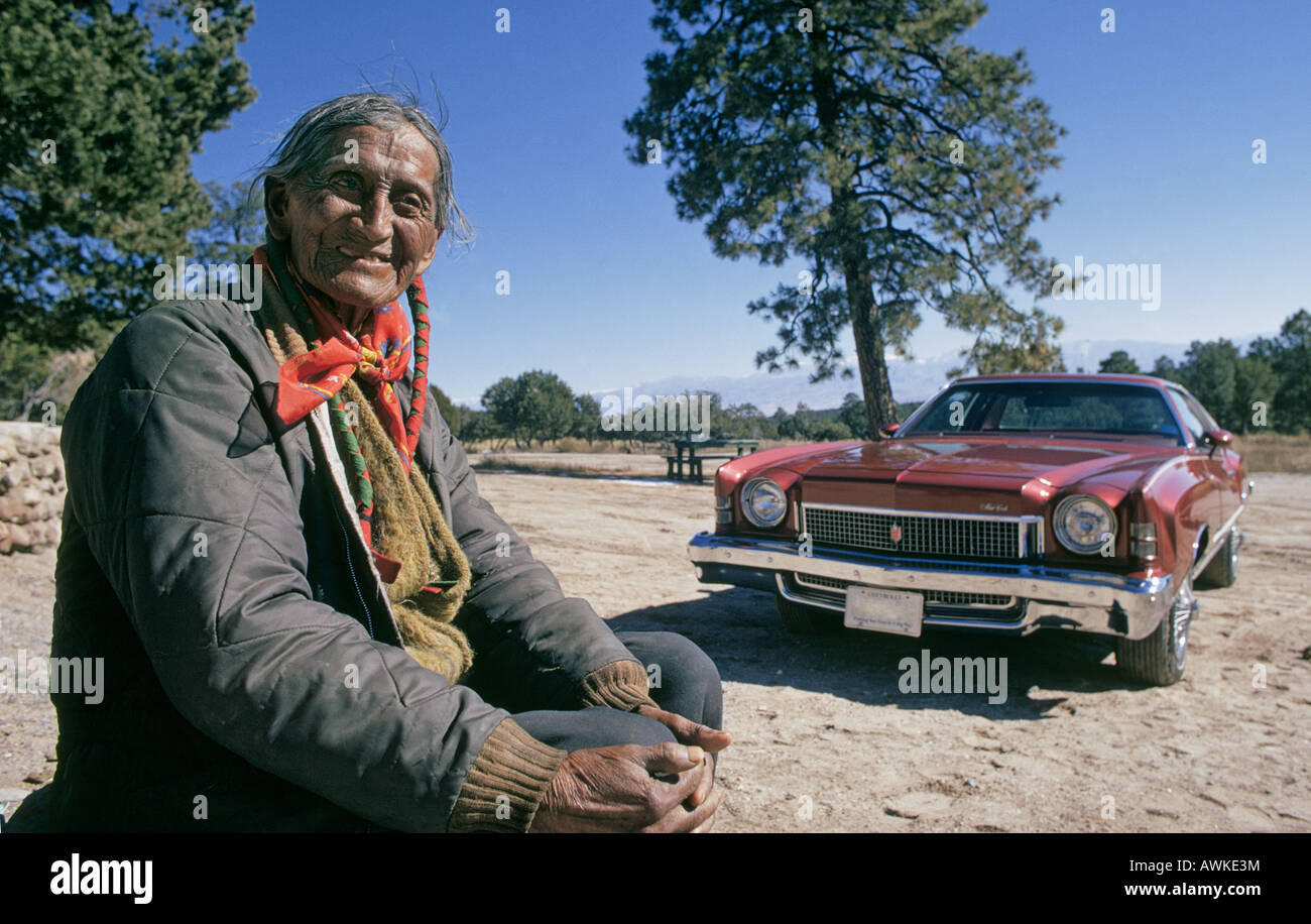 Eine ältere Santa Clara Pueblo-Indianer sitzt Man mit einem klassischen Chevrolet in der Nähe seines Hauses im Bereich Puye Cliffs Stockfoto