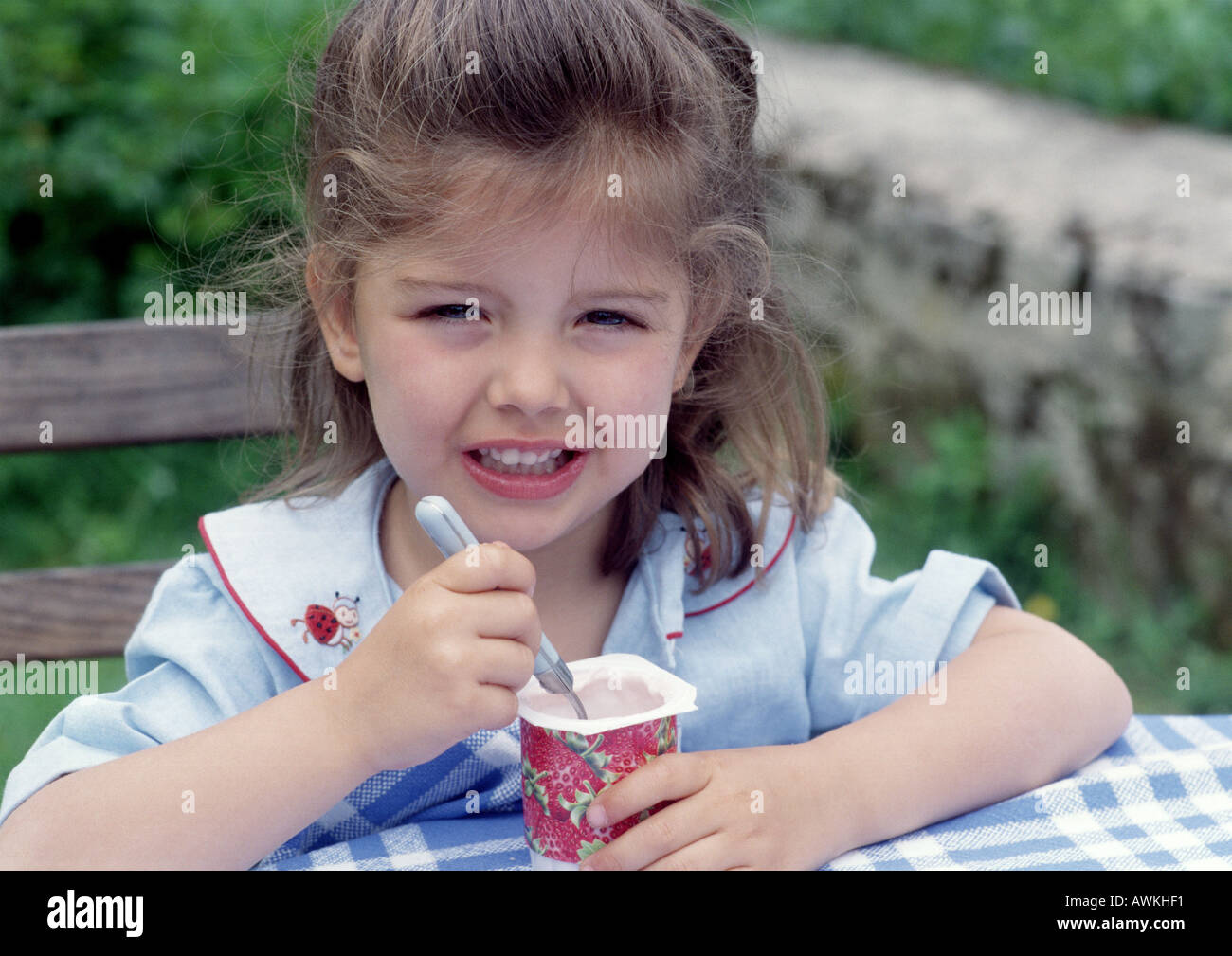 Junges Mädchen Essen Joghurt außerhalb. Stockfoto