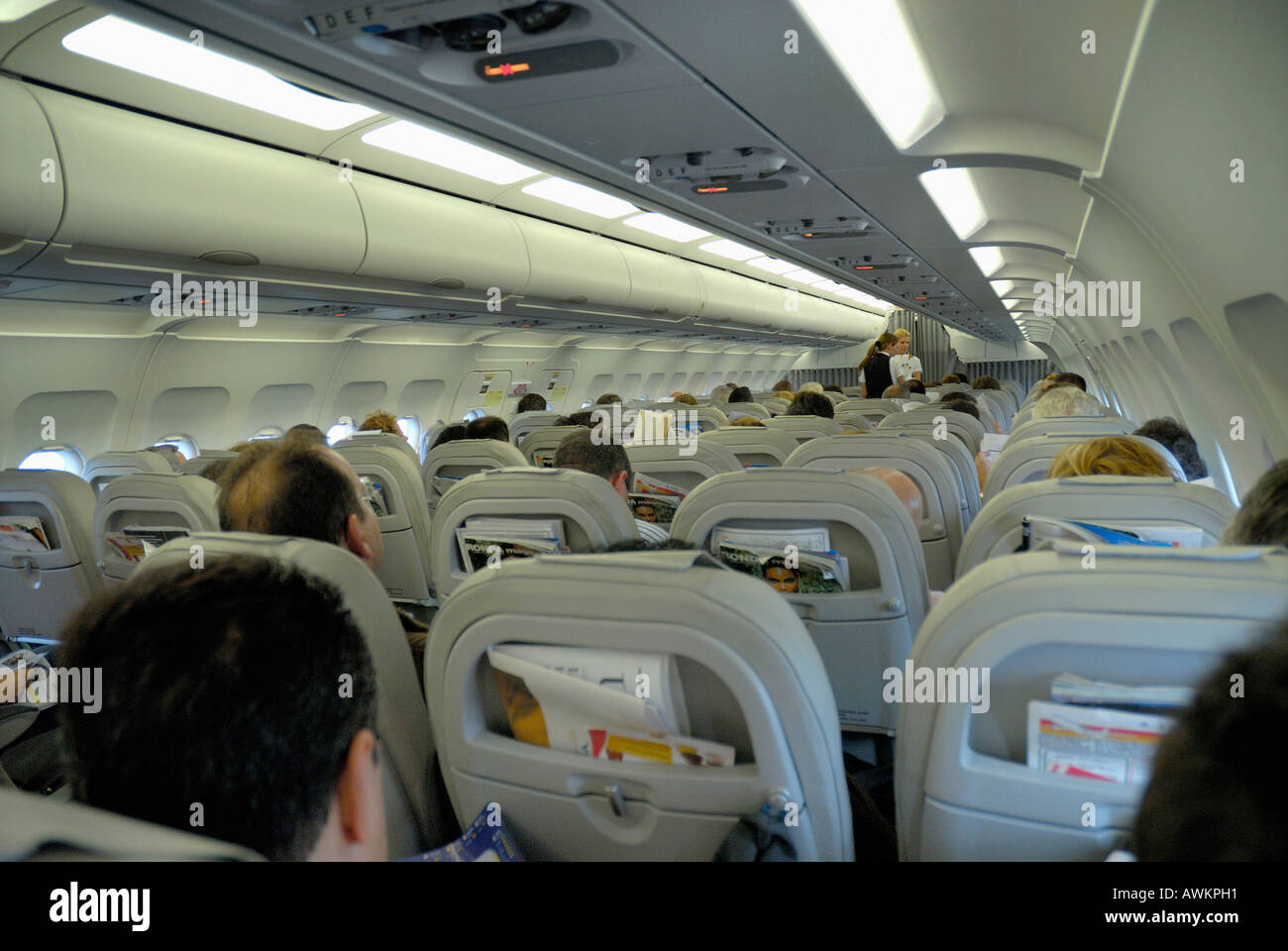 PASSAGIERE SITZEN IM FLUGZEUG WÄHREND DES FLUGES Stockfoto