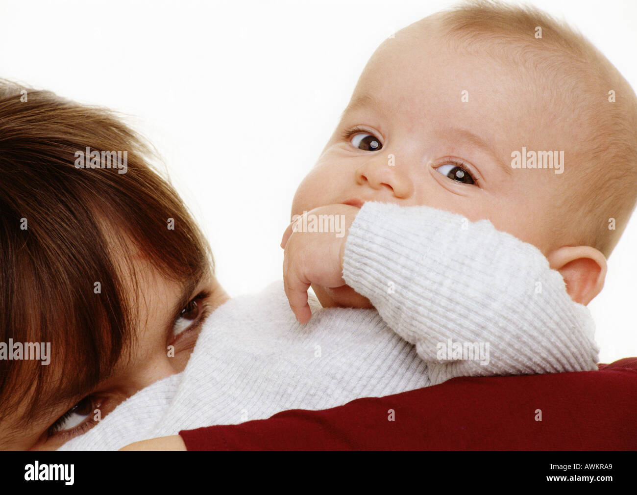 Baby mit der Hand im Mund Blick in die Kamera, Frau, oberen Teil des Kopfes, blickte zu Baby, Nahaufnahme Stockfoto