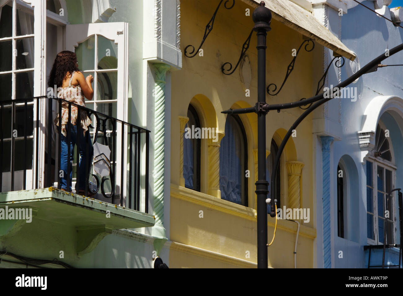 Eine Frauen tief in Gedanken über den Balkon im ersten Stock eines Gebäudes im neuen Regent Street, Christchurch, Neuseeland Stockfoto
