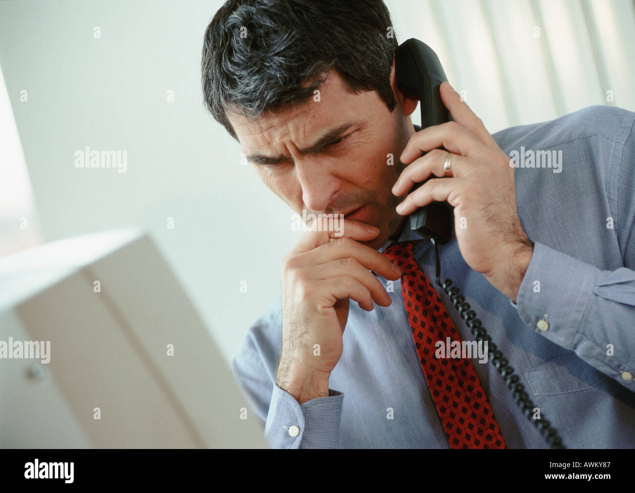 Geschäftsmann am Telefon, gerunzelter Stirn Stockfoto