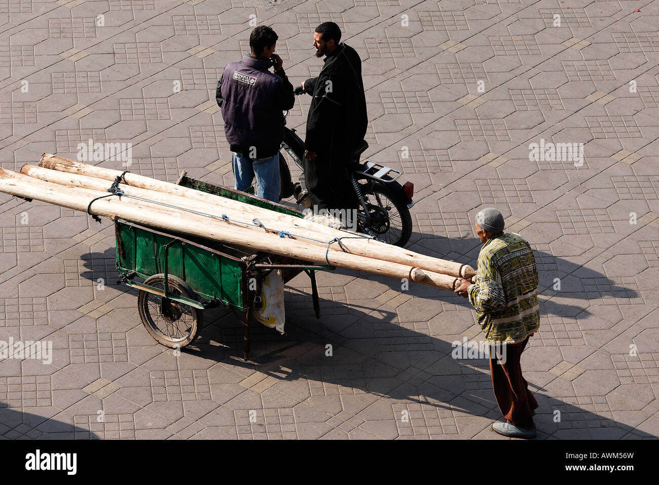Mann, Schieben Karren geladen mit Holzbalken, Djemaa el Fna, Marrakesch, Marokko, Afrika Stockfoto