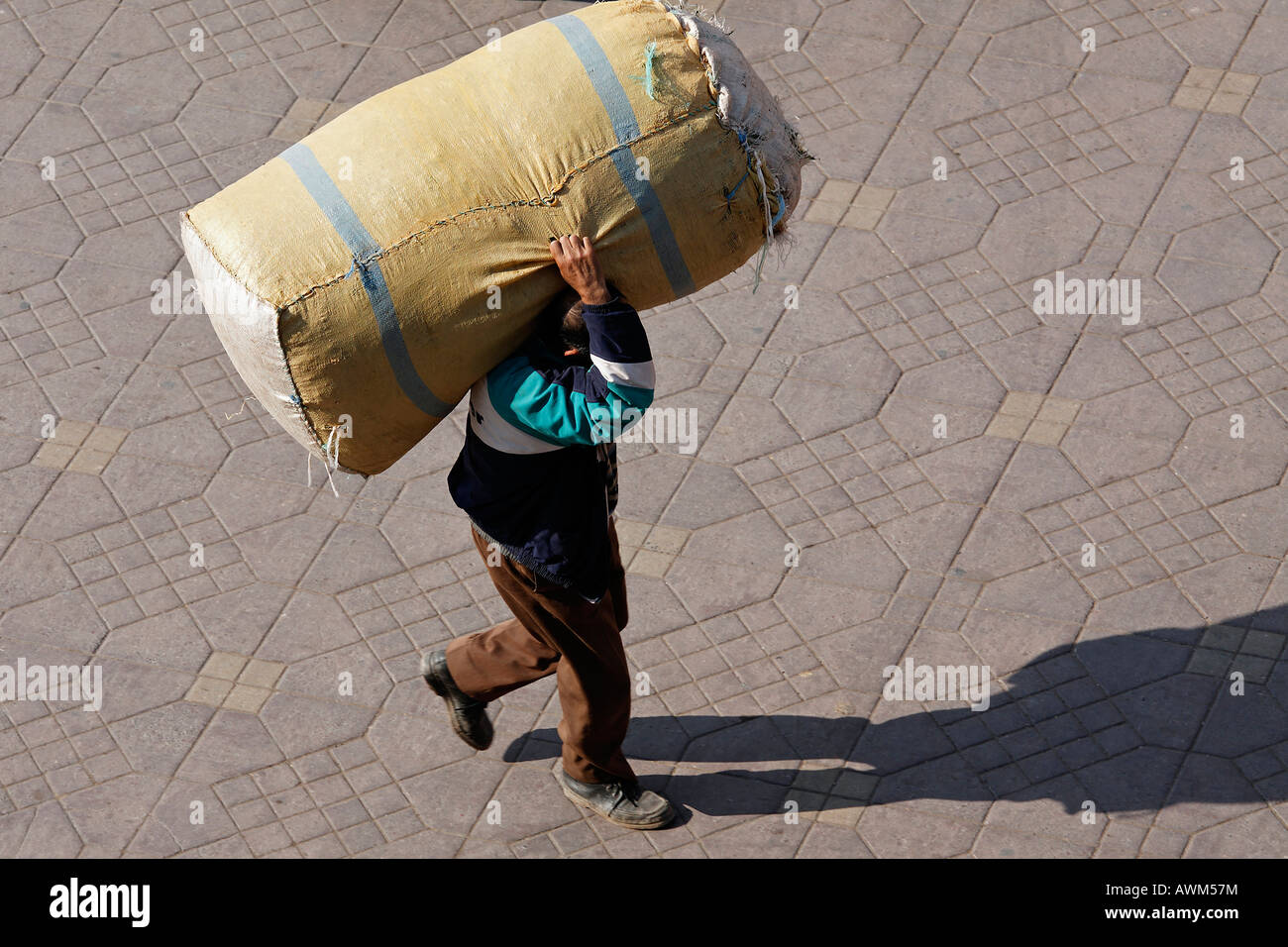 Mann trägt ein großes Paket auf seinen Schultern, Djemaa el Fna, Marrakesch, Marokko, Afrika Stockfoto
