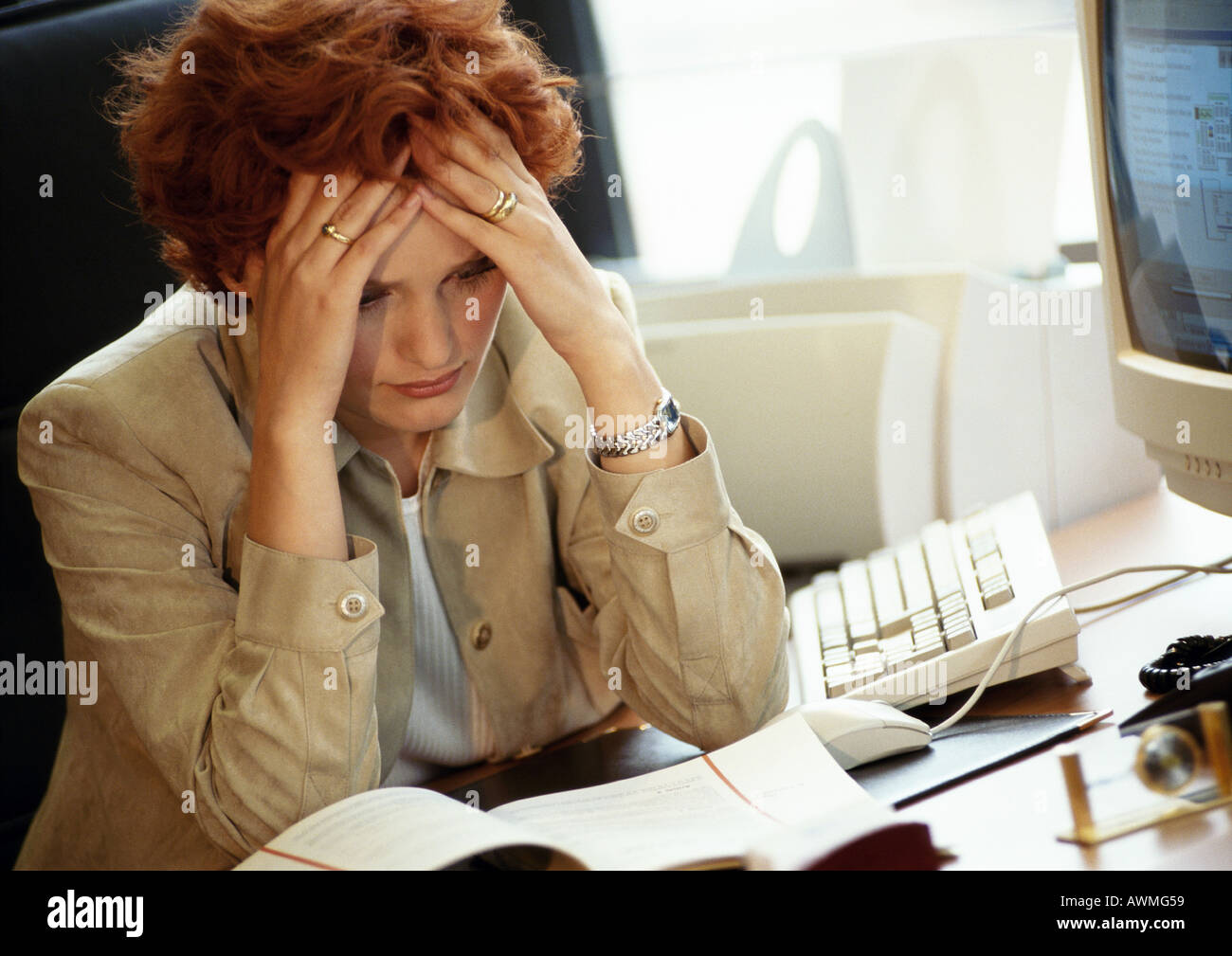 Geschäftsfrau sitzen am Schreibtisch, die Hände auf den Kopf Stockfoto