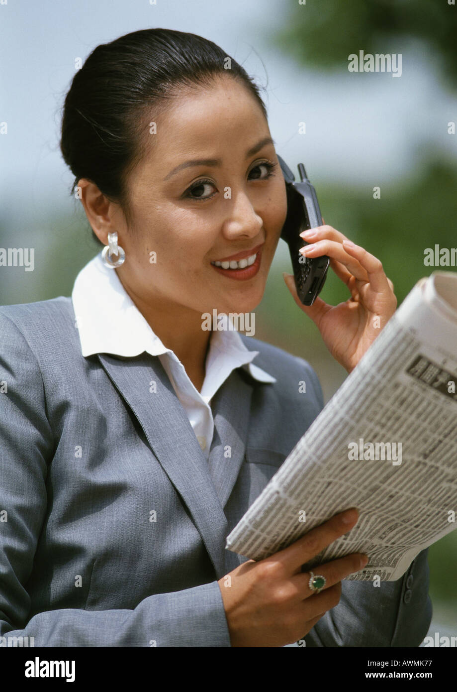 Geschäftsfrau mit Handy, Holding Zeitung, portrait Stockfoto