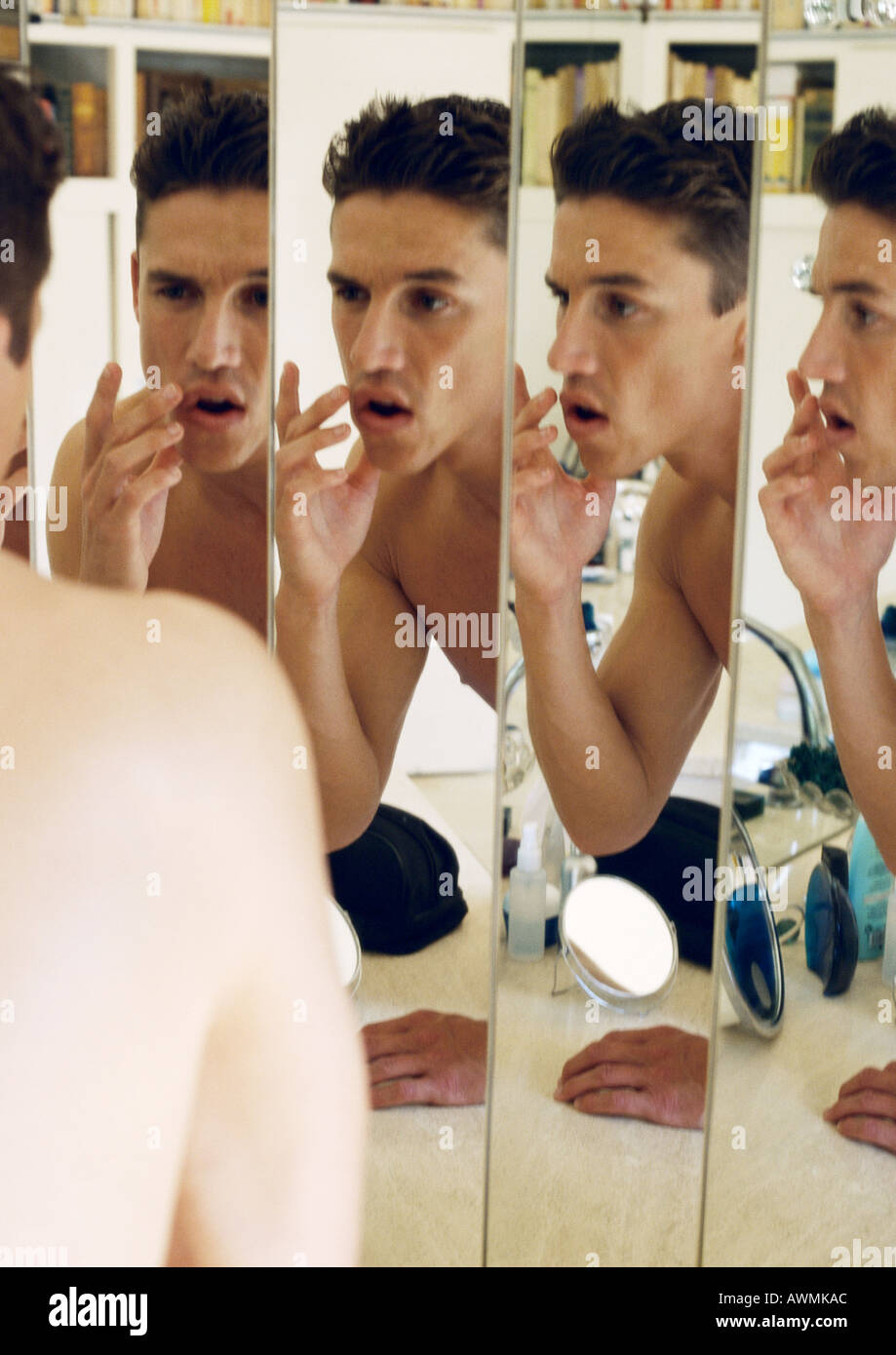 Mann berühren Lippen, reflektiert im Spiegel Stockfoto