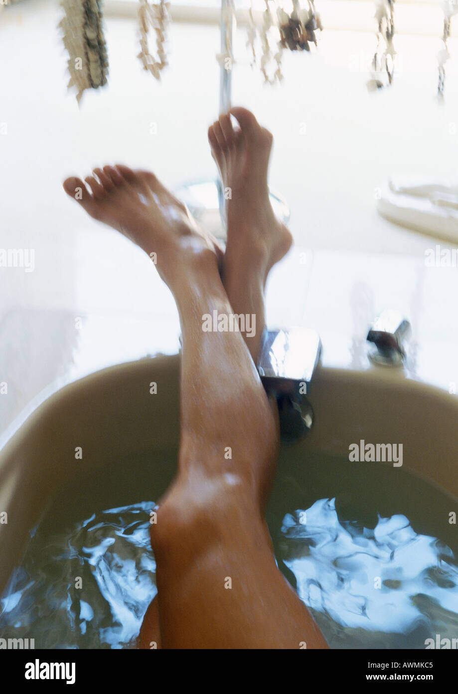 Beinen ragte aus der Badewanne Stockfoto