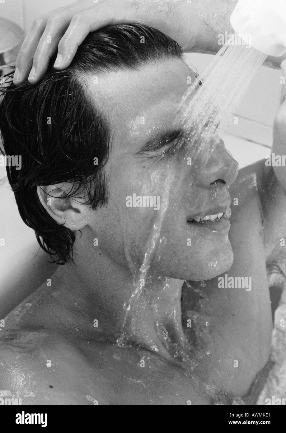 Mann in Badewanne, Spülen Gesicht, b&w Stockfoto