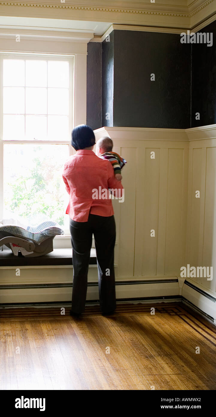 Mutter Baby Holding neben Fenster Stockfoto