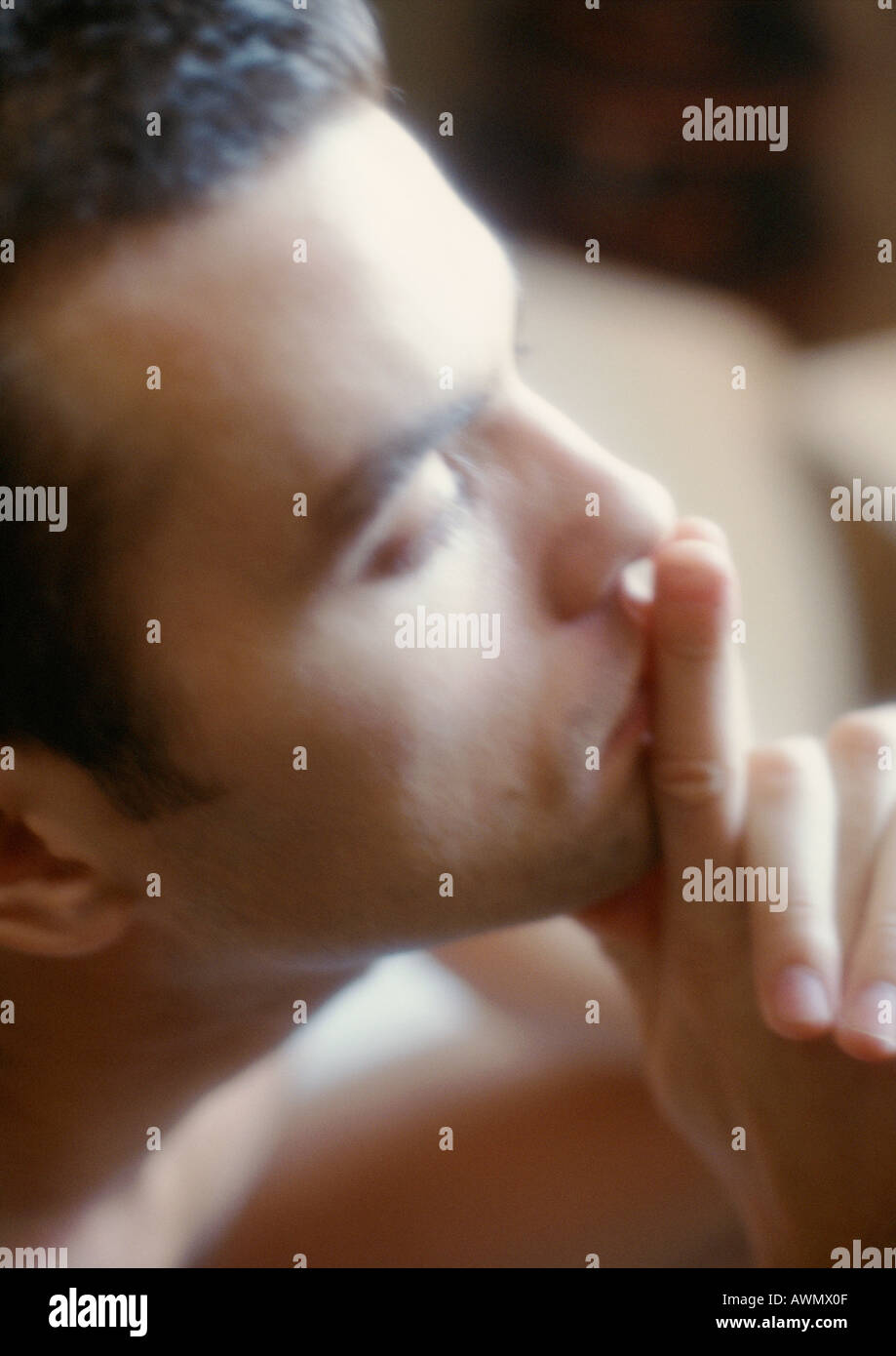 Mann hält Finger vor den Lippen, Seitenansicht, Nahaufnahme, soft-Fokus Stockfoto