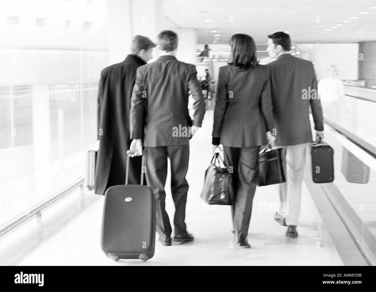 Gruppe von Geschäftsleuten, die zu Fuß durch terminal, volle Länge, Rückansicht, b&w. Stockfoto