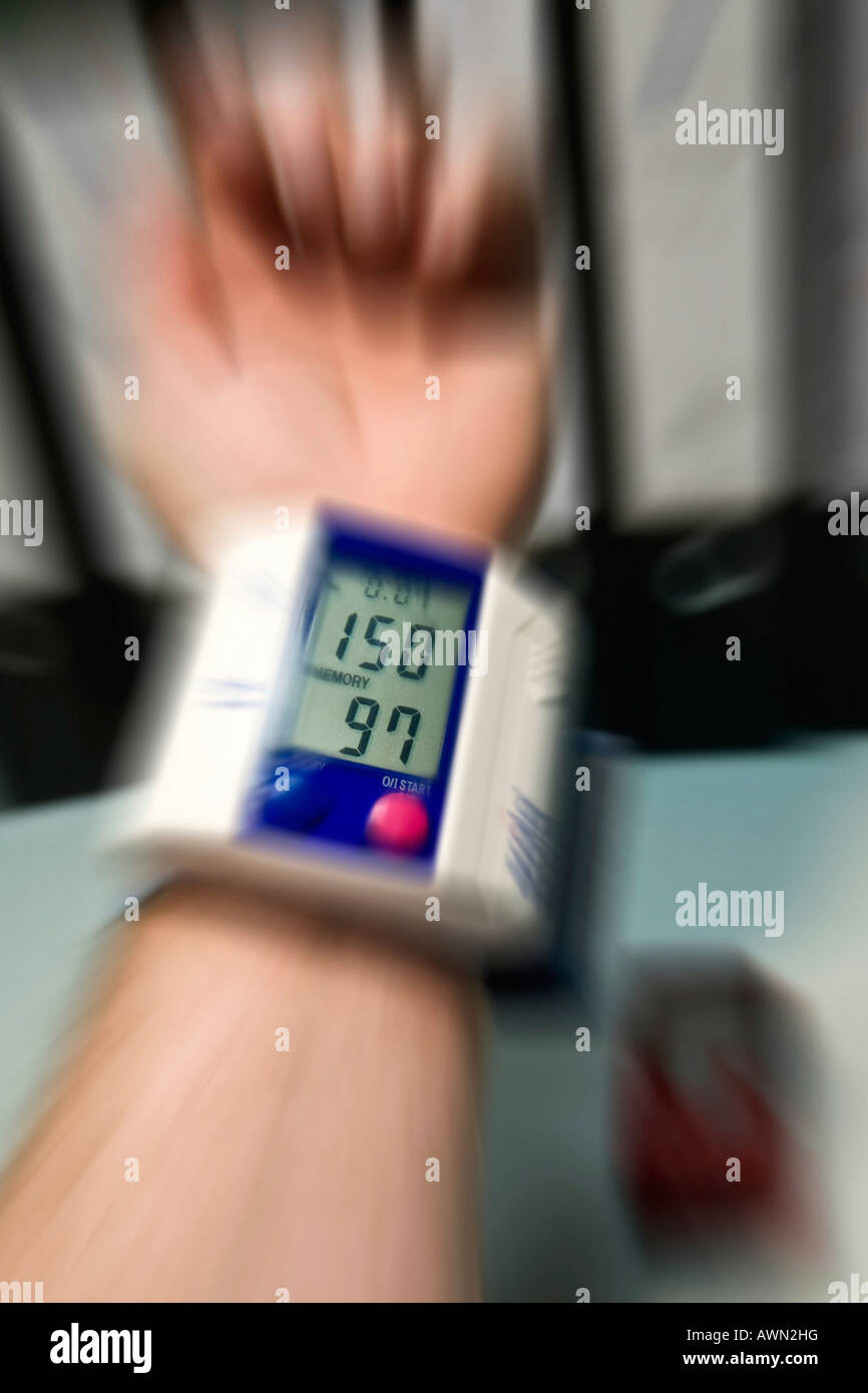 Mann überprüfen sein Blutdruck im Büro Stockfoto