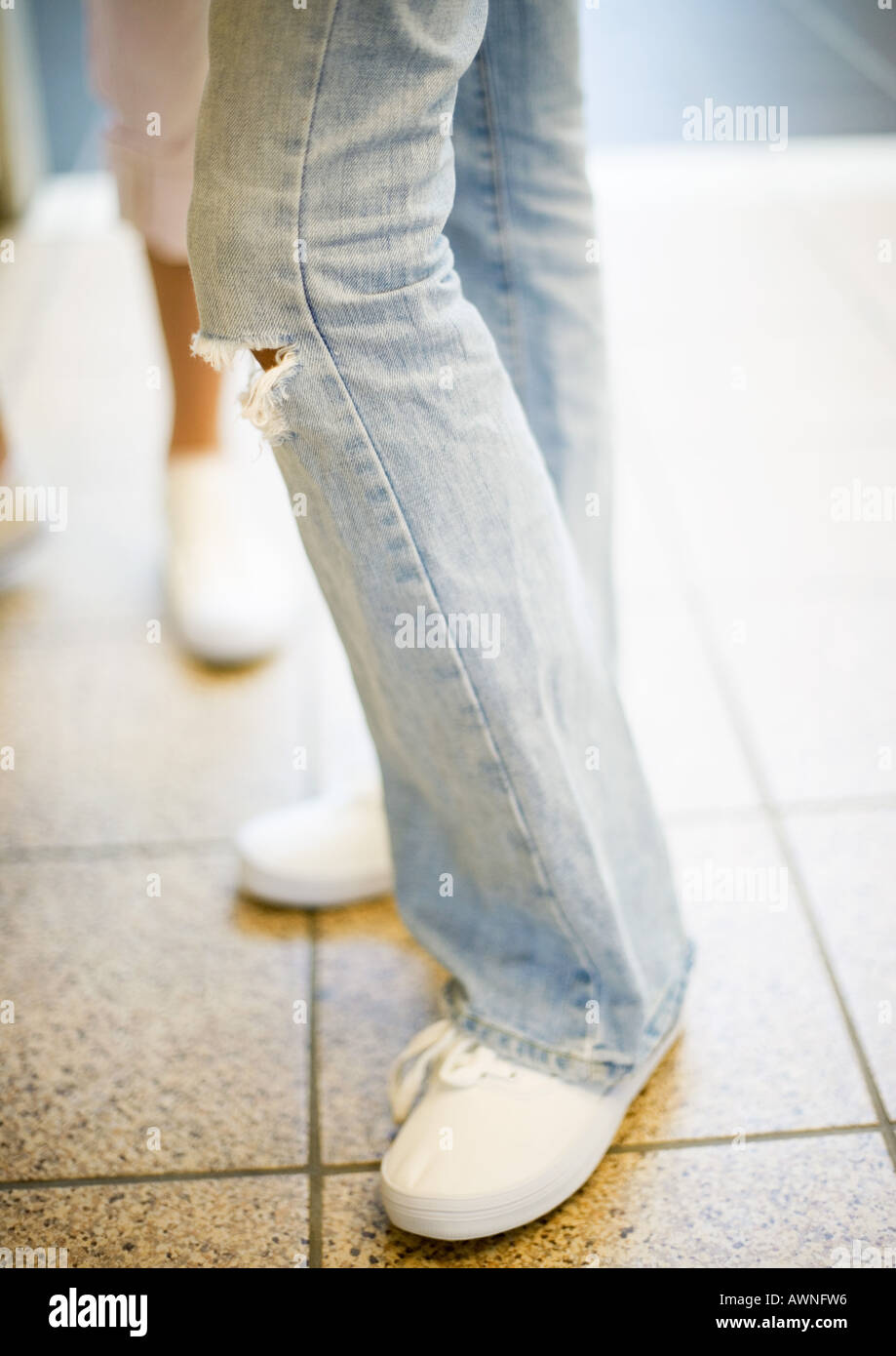 Teenager-Mädchen in Jeans mit Loch am Knie, Nahaufnahme des Knies nach  unten Stockfotografie - Alamy
