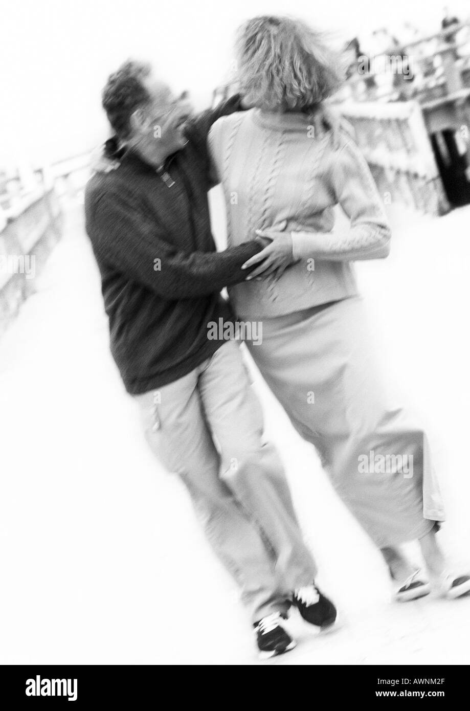 Älteres Paar halten einander am Boardwalk, verschwommen, B&W Stockfoto