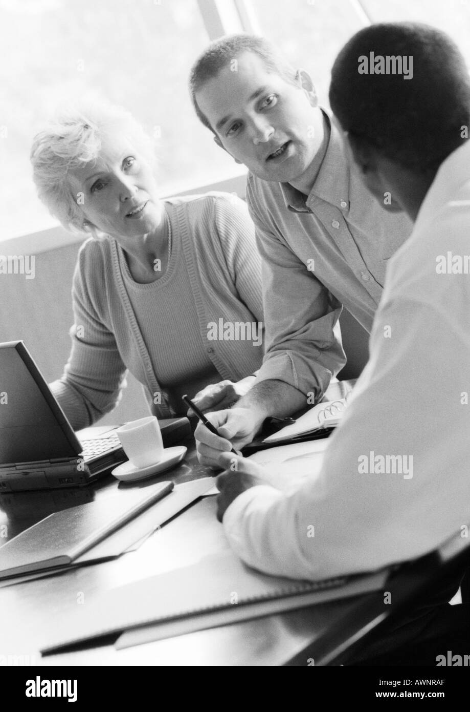 Reife Geschäftsfrau in Konferenz mit zwei Geschäftsleute, B&W Stockfoto