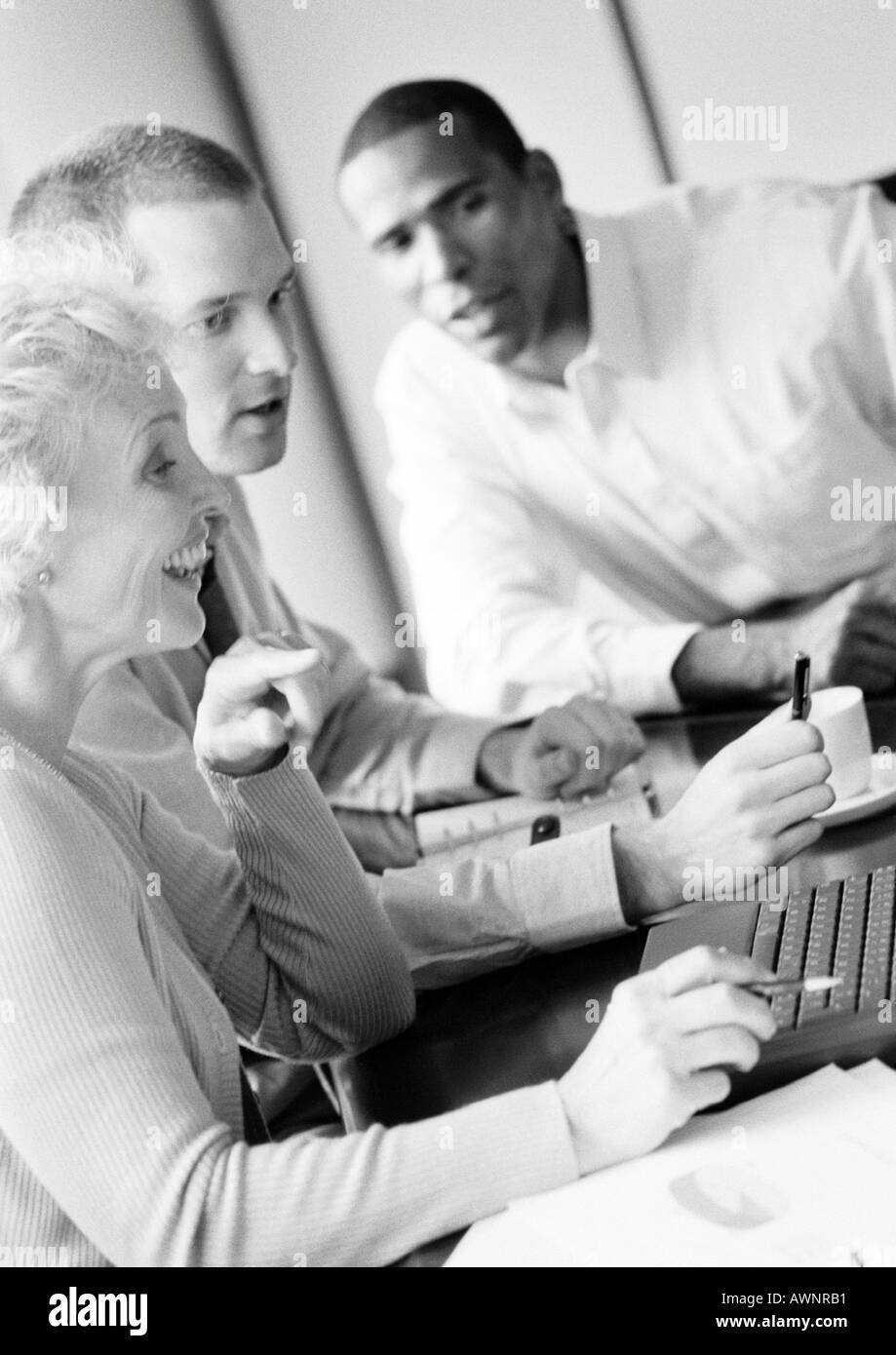 Reife Geschäftsfrau in Konferenz, smiling, Profil, mit zwei Geschäftsleute, B&W Stockfoto