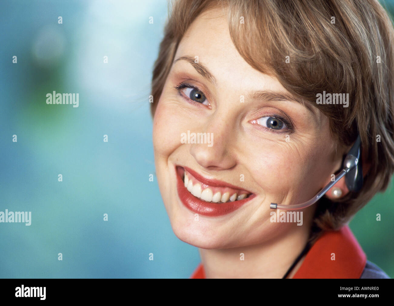 Frau trägt Kopfhörer, lächelnd in die Kamera, Nahaufnahme, Porträt Stockfoto