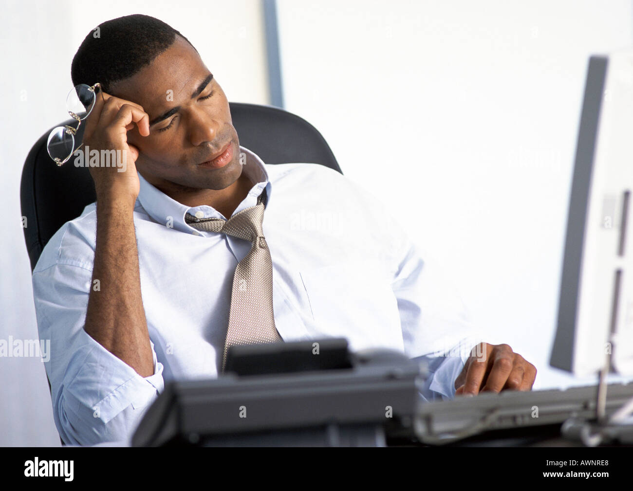Geschäftsmann am Schreibtisch sitzen mit geschlossenen Augen Stockfoto