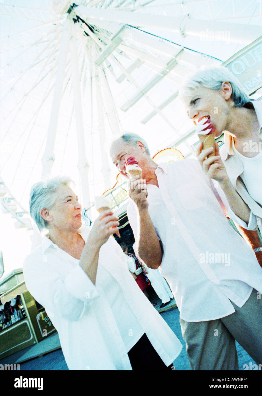 Pensionierte Freunde essen Eis im Vergnügungspark Stockfoto