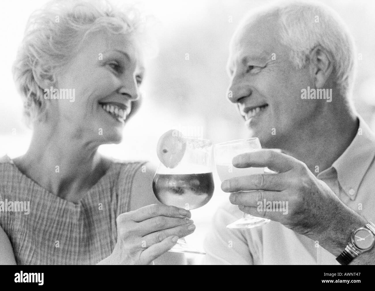Reifer Mann und Frau klirrende Gläser, Nahaufnahme, B&W Stockfoto