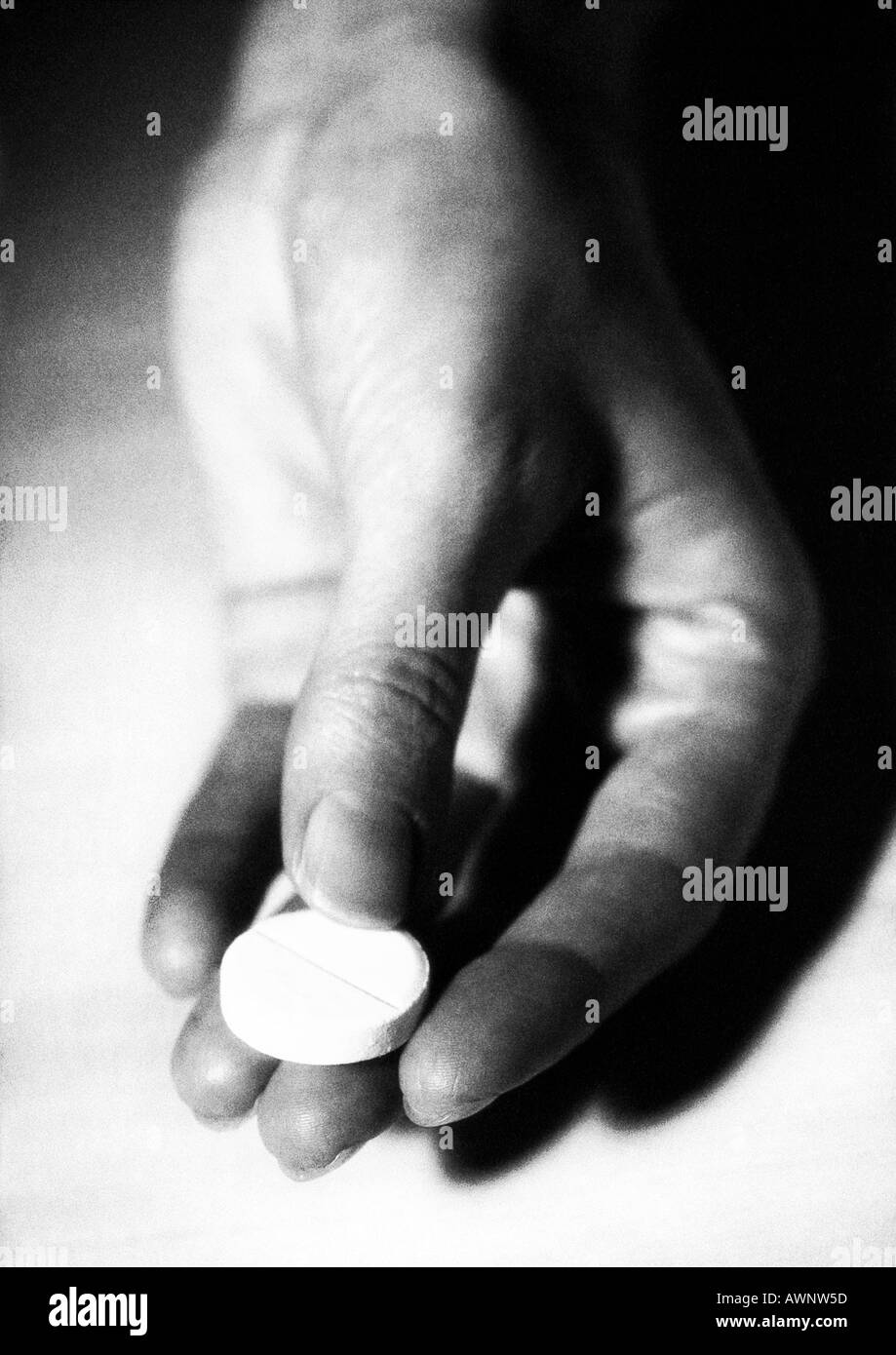 Hand mit einem Medizin-Tablette, B&W Stockfoto