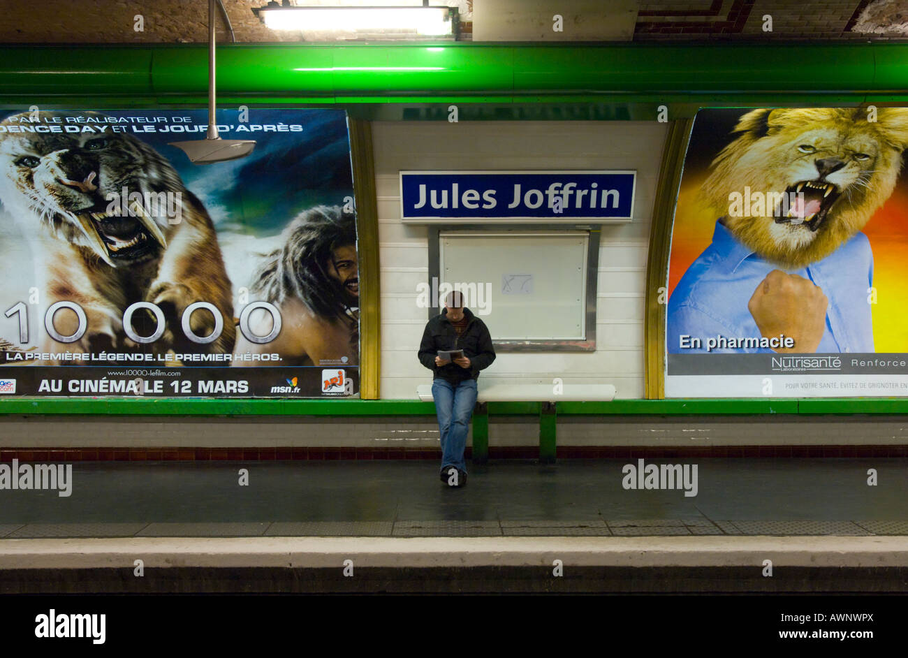 Frankreich Paris 18 u-Bahnhof Jules Joffrin Mann allein warten auf Zug am Bahnsteig mit riesigen Werbeplakate bkgd Stockfoto